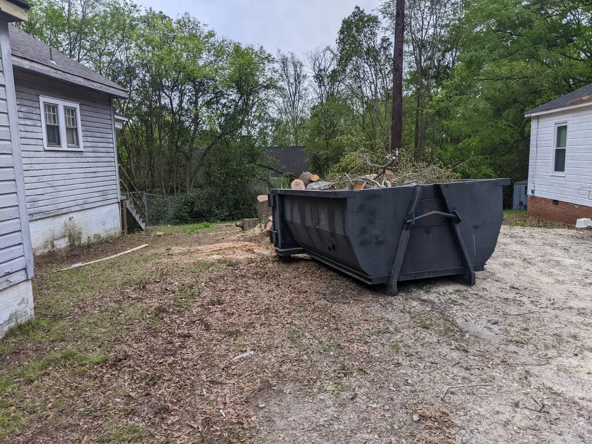 A dumpster with debris in it on the side of a road.