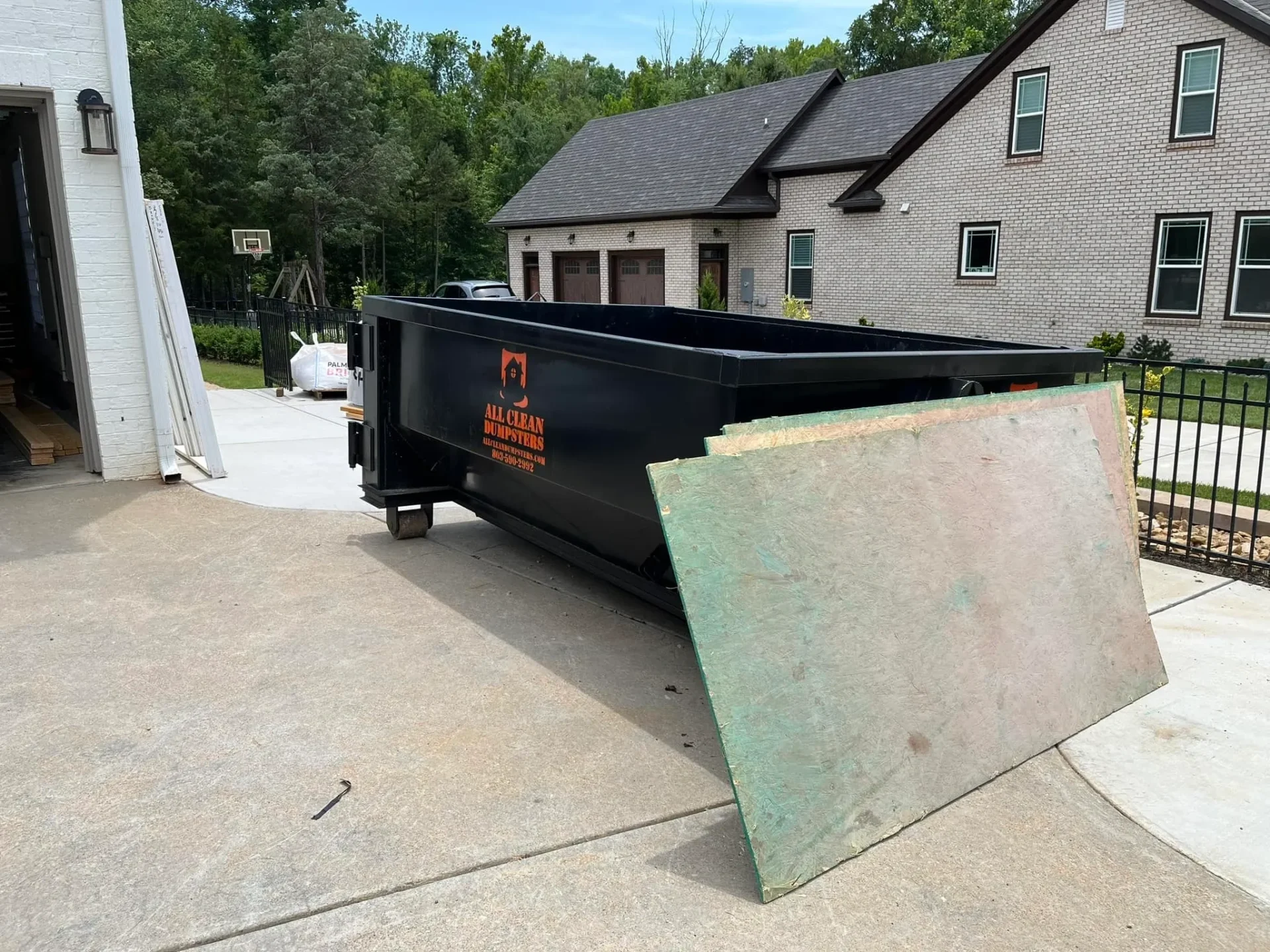 A dumpster sitting in the middle of a driveway.