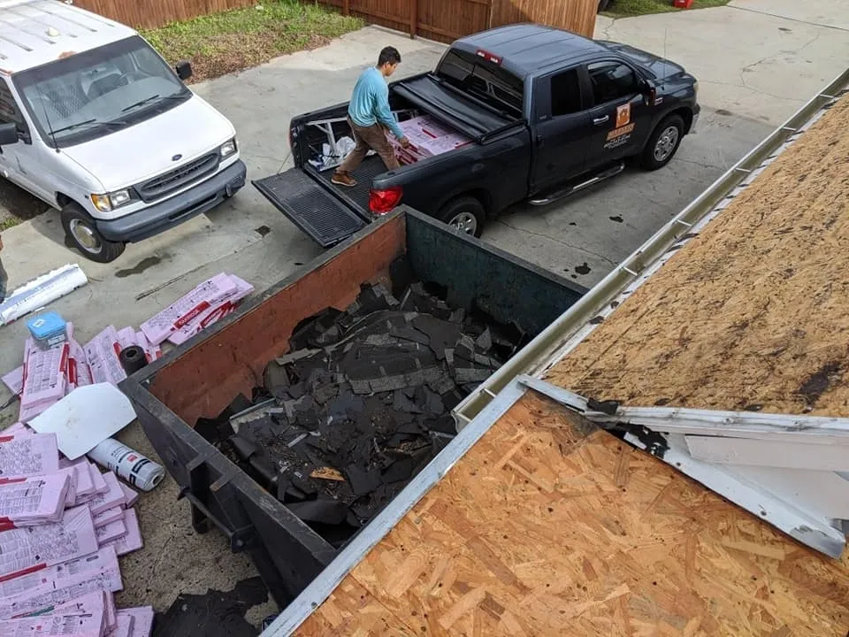 A man unloading debris from the back of his truck.